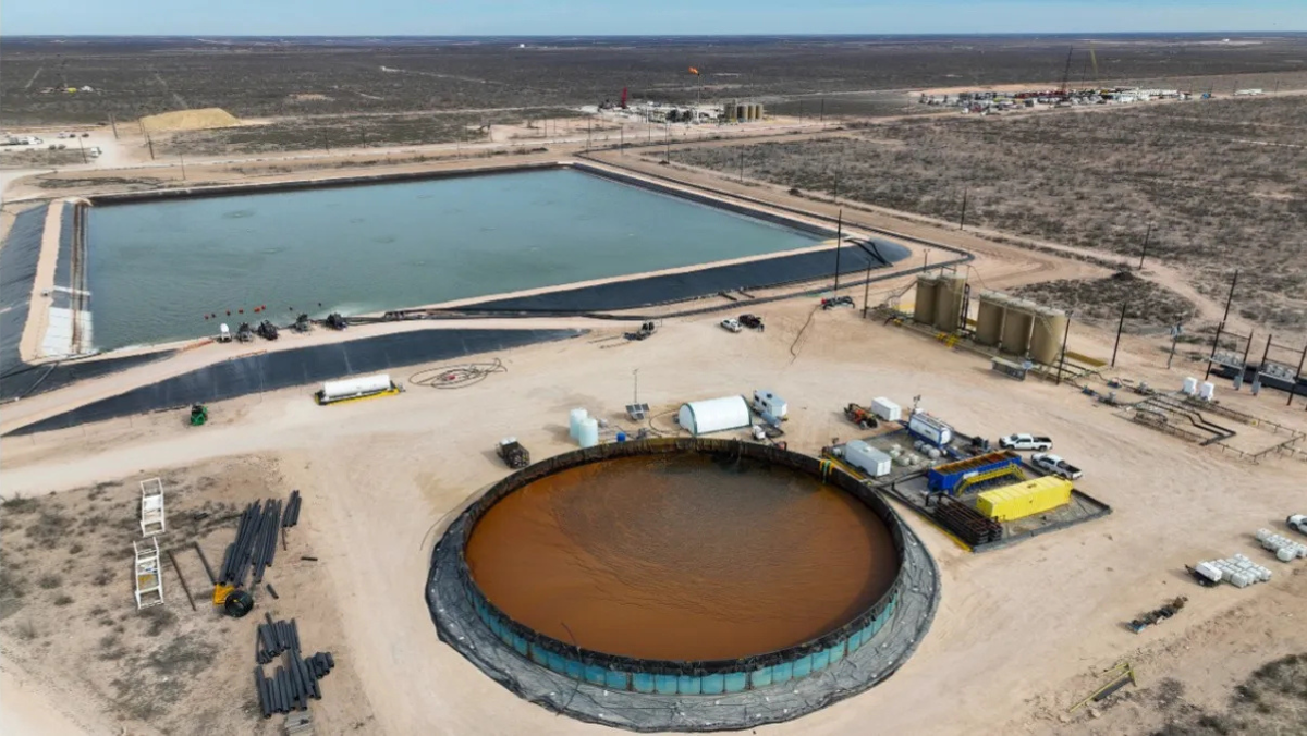 Shale water facility with large lined ponds and treatment units used for produced-water recycling.