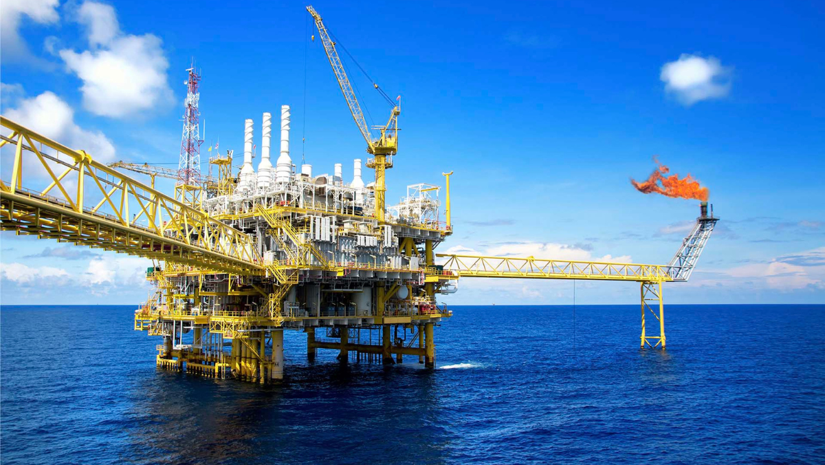 Offshore oil platform with flare stack and water surrounding the production facility.