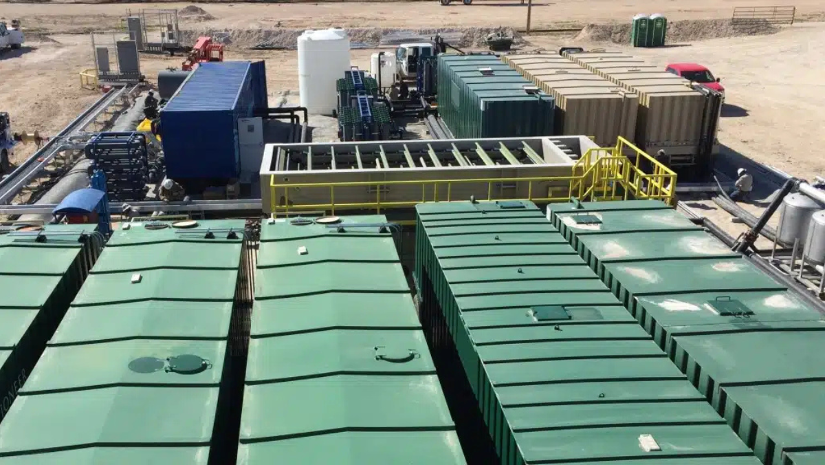 Produced-water treatment units and modular equipment operating at a Permian oilfield site.
