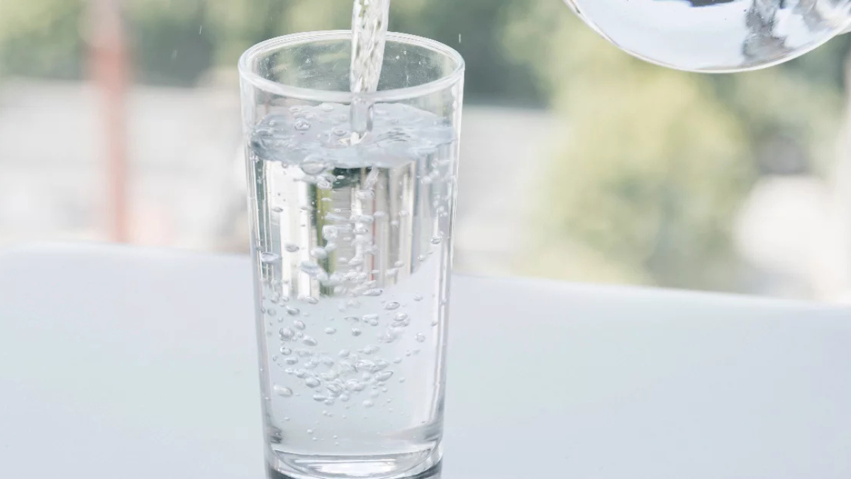 Water being poured into a clear glass, illustrating produced water concepts