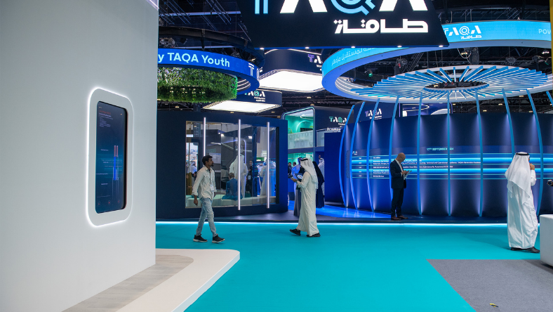 Energy exhibition stand with digital displays and visitors in the Middle East